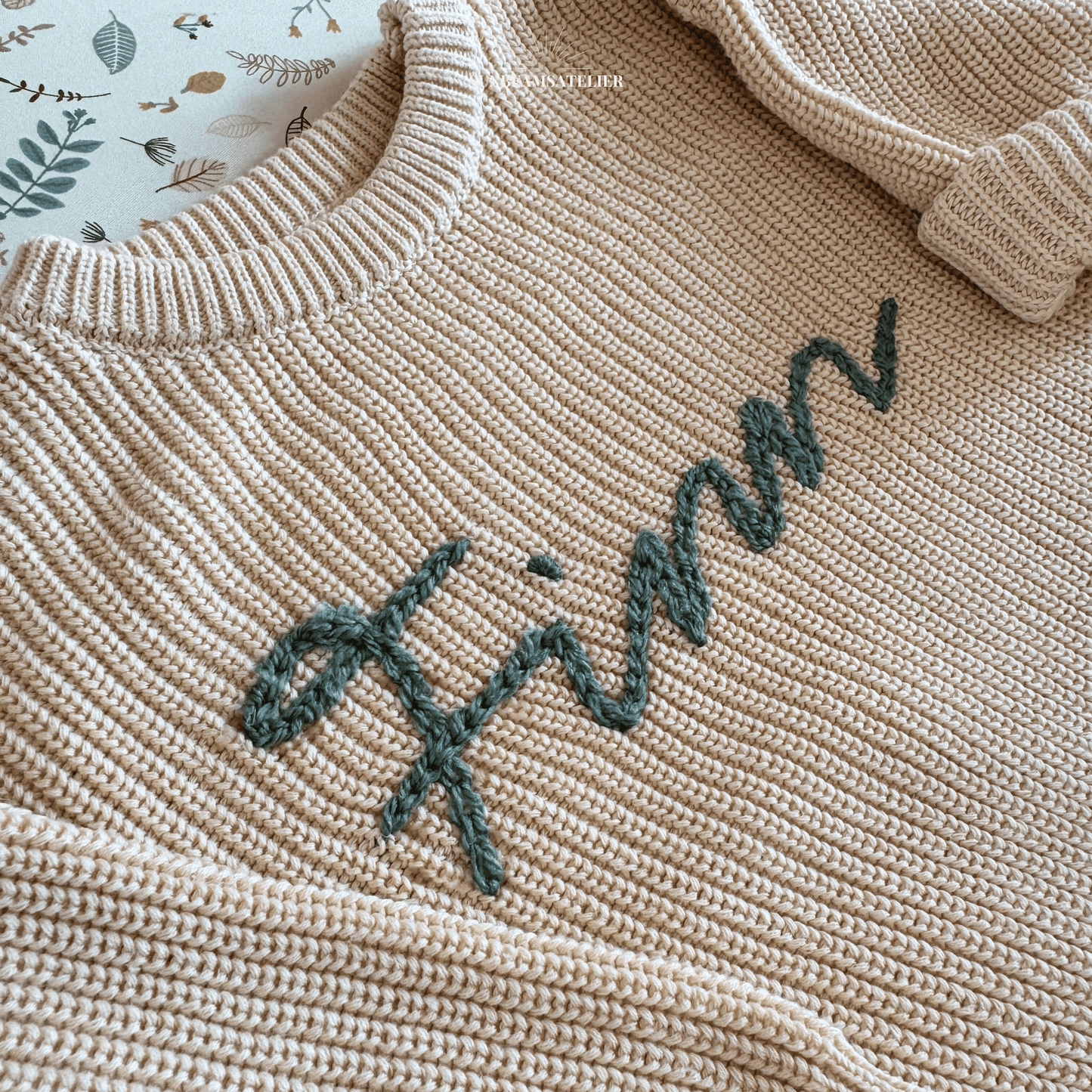 Strickpullover in Ivory mit einem bestickten Schriftzug "Finn" in Mintgrün