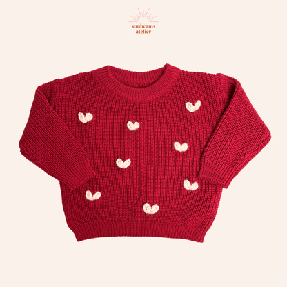 Produktbild mit einem roten Strickpullover und vielen großen rosa und hellen bestickten Herzchen mit chunky Garn