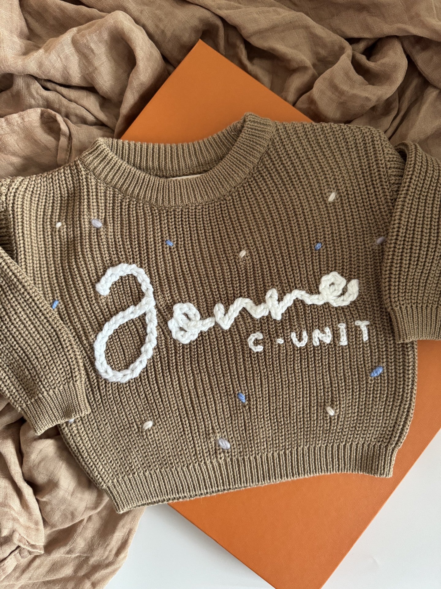 Personalisierter Kinderpullover mit handbesticktem Namen