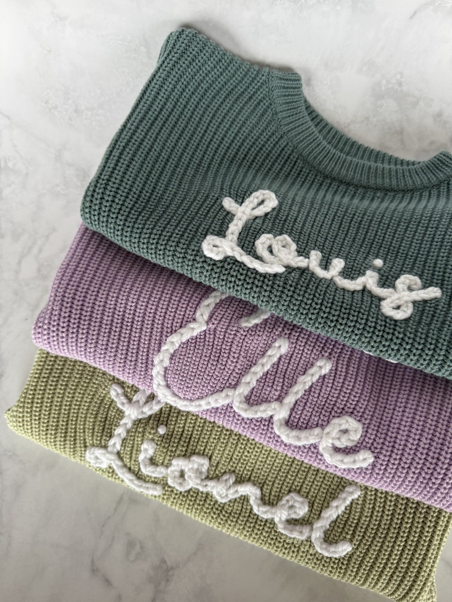 Personalisierter Kinderpullover mit handbesticktem Namen